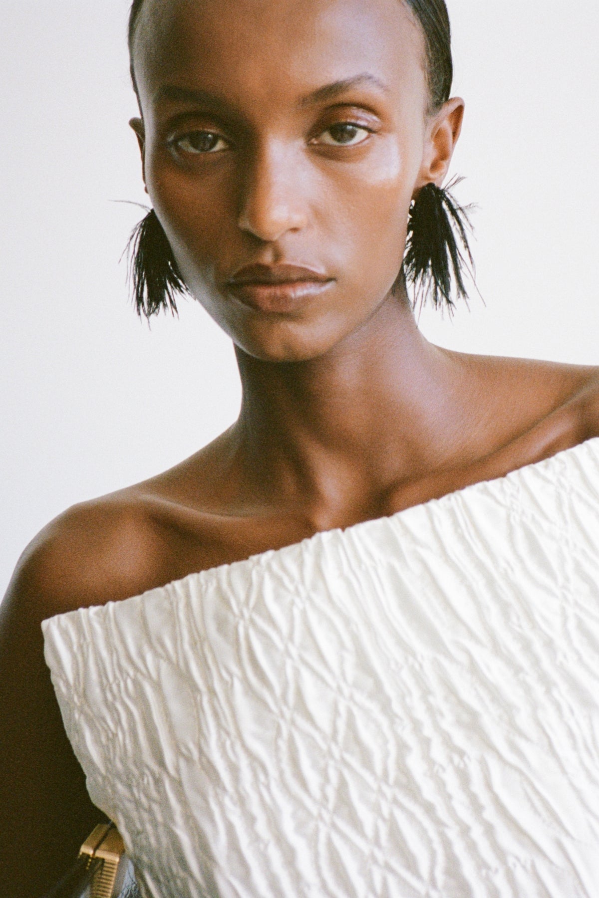 Styled view CAMILLA AND MARC Friesian Feather Earrings in Black featuring sculptural soft‑spike hoops fitted with black faux ostrich feathers.
