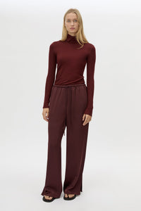 Front view CAMILLA AND MARC Barre High Neck Top in Burgundy styled with the Ground Satin Pant.