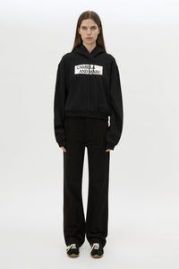 Front styled view CAMILLA AND MARC Carmont Graphic Hoodie in Black with boxy fit and black graphic logo.