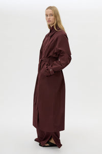 Side view CAMILLA AND MARC Dia Trench Coat in Burgundy with long‑line cut.