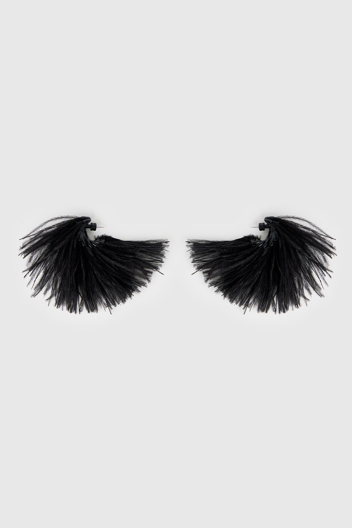 Side view CAMILLA AND MARC Friesian Feather Earrings in Black featuring sculptural soft‑spike hoops fitted with black faux ostrich feathers.
