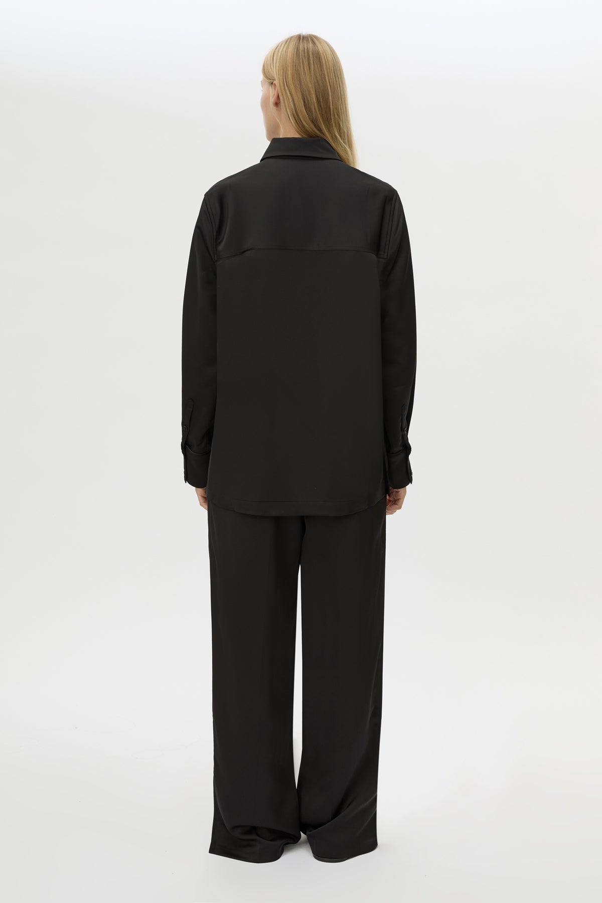 Back view CAMILLA AND MARC Ground Satin Long Sleeve Shirt in Black with collared neckline.