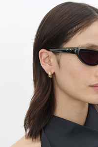 Side view CAMILLA AND MARC Koa Huggies in two‑tone 18k gold and rhodium plating.