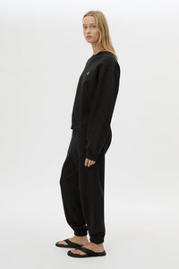 Side styled view CAMILLA AND MARC Lyra Embroidered Tracksuit Top in Black and White with relaxed fit.