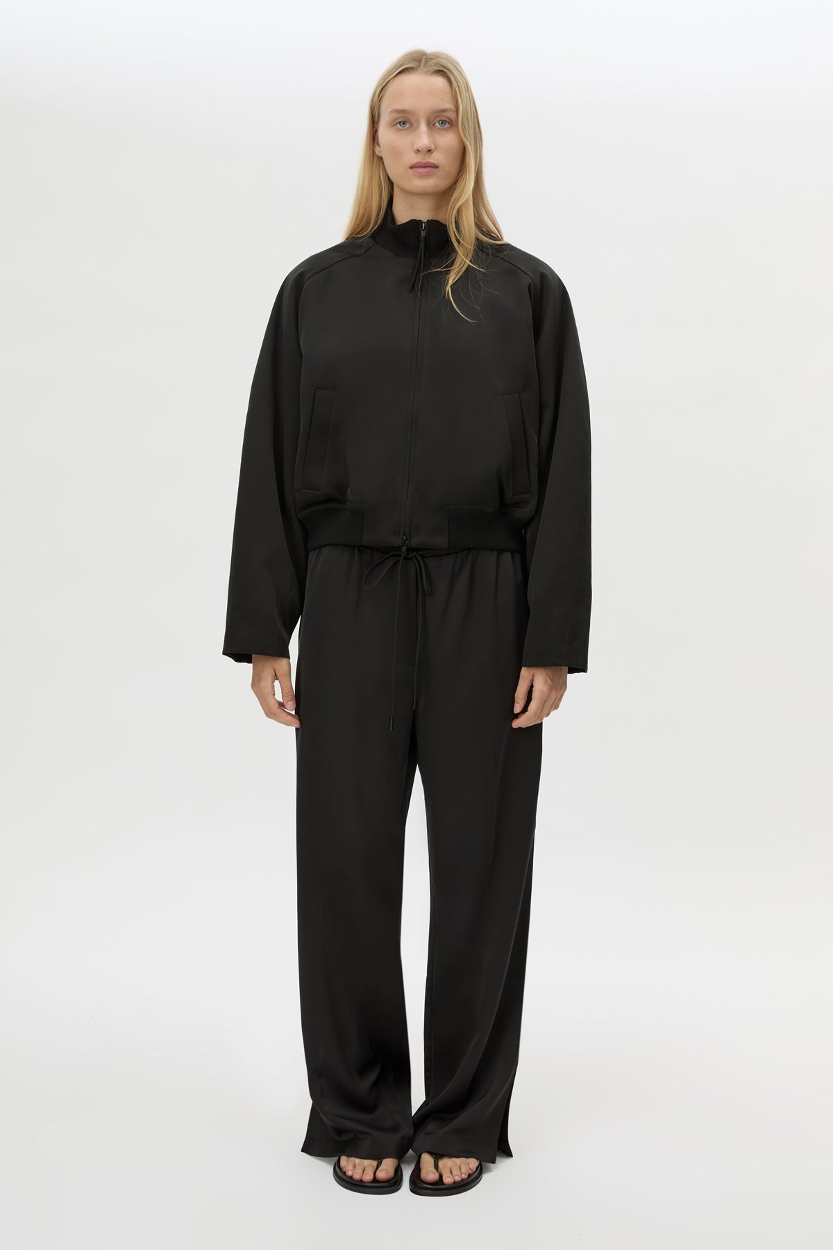 Front view CAMILLA AND MARC Tamar Satin Bomber Jacket in Black with front zipper.