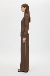 Side view CAMILLA AND MARC Axial Top in Chocolate with layered cross‑over high neck.